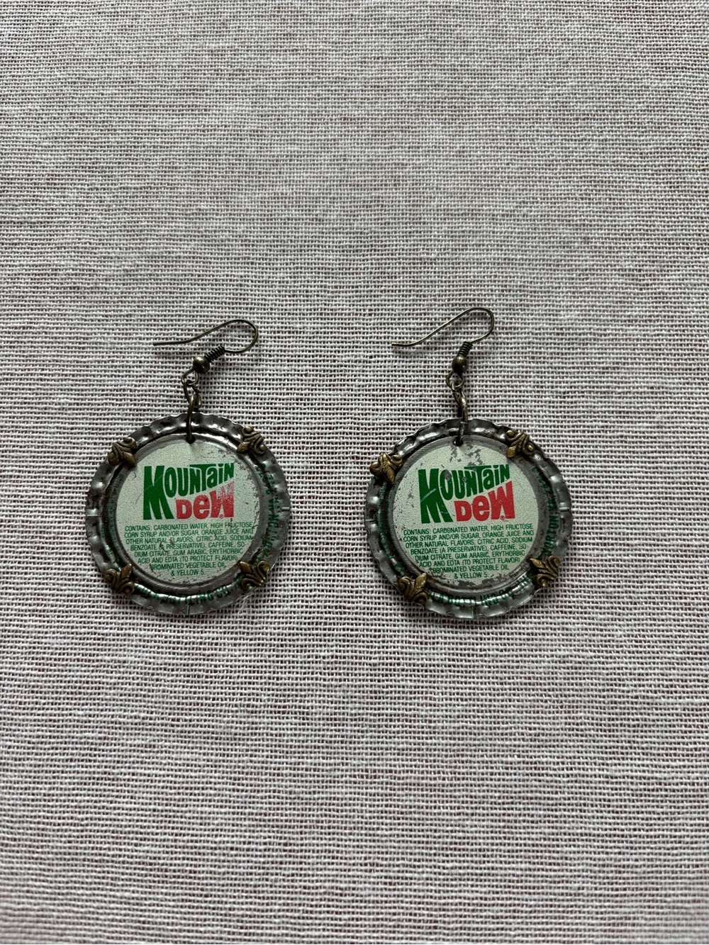 Handcrafted artisan hammered bottle cap earrings.